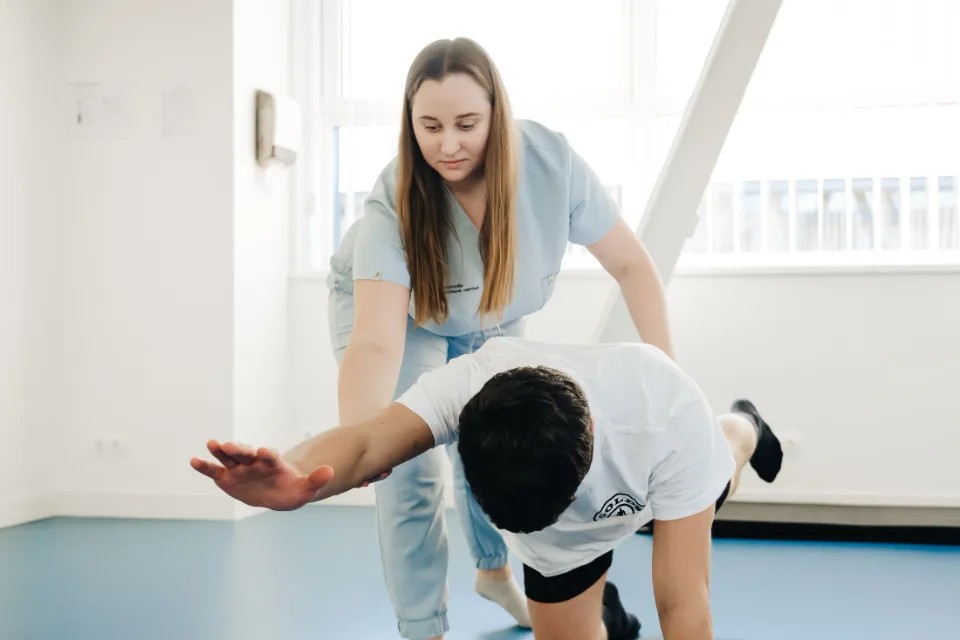 Fisioterapeuta ajudando uma paciente em exercício de alongamento