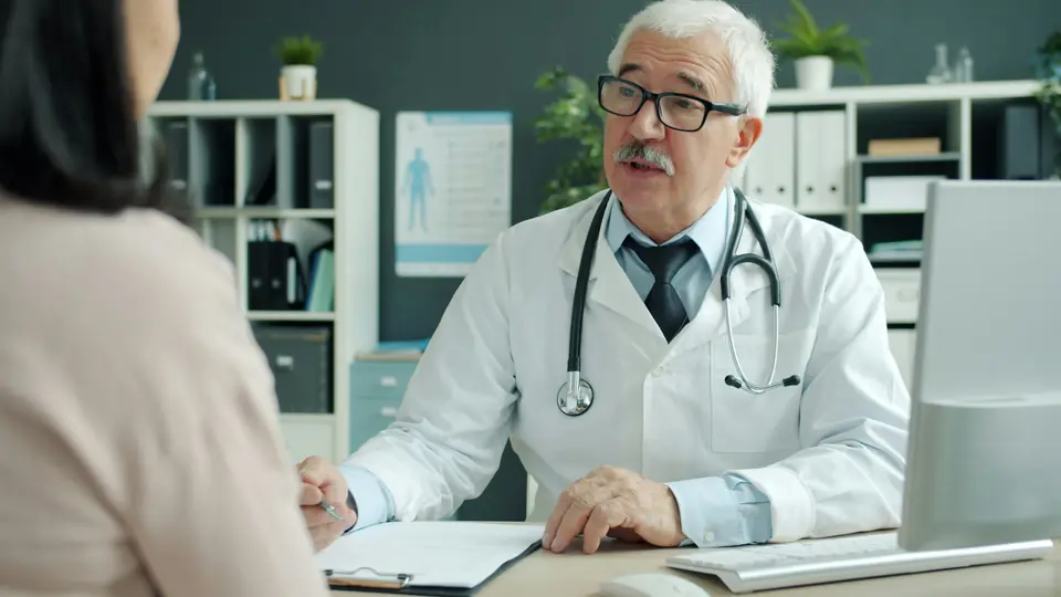 Médico conversando com uma paciente no consultório